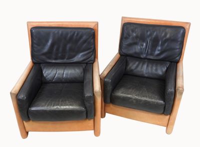 pair of black leather lounge chairs with wooden frame and arms