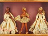 three dolls that are in a shadow box together
