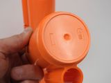 a person holding an orange blow dryer in their hand