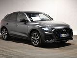 a grey audi qx parked in a white room