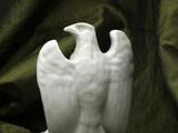 a white statue of an eagle on a green cloth