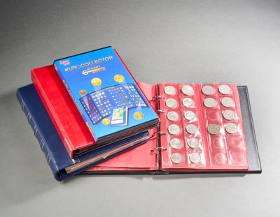 a red book with a blue cover sitting next to a stack of coins
