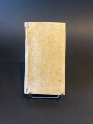 an old book sitting on top of a table on a black surface