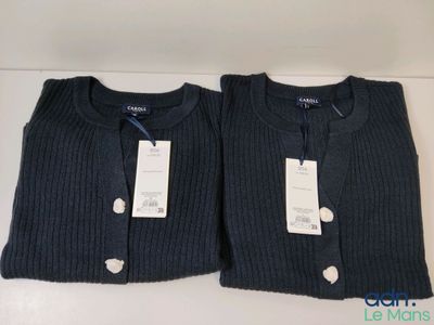 une paire de pulls pour homme, encore étiquetés, posés sur une table