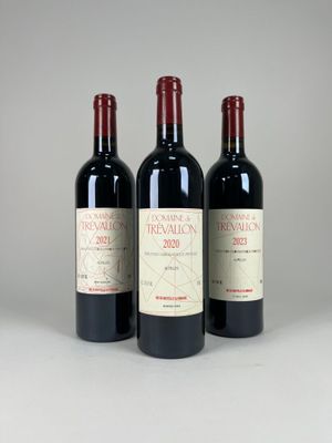 three bottles of red wine sitting next to each other on a table