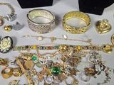 many different types of jewelry on display on a table