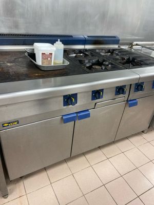 a large stainless steel stove top in a commercial kitchen