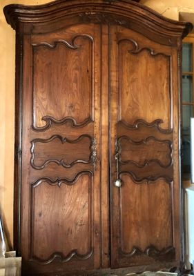 a large wooden armoire in the corner of a room