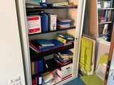 a room with a bookcase and a chair in it