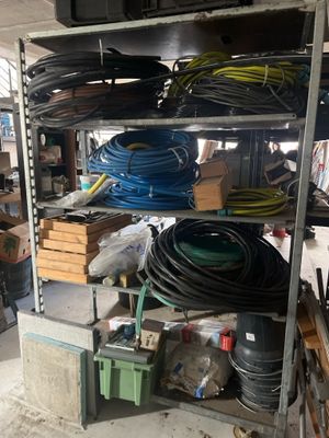 many different types of hoses on the shelves in the garage