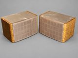 pair of vintage speakers in cardboard boxes on a gray background