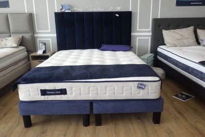 un lit recouvert d'un couvre-lit rayé bleu et blanc dans une chambre