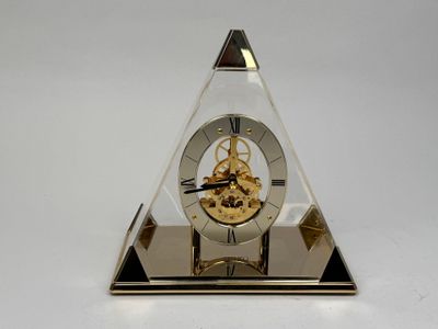 une horloge posée sur un socle en verre