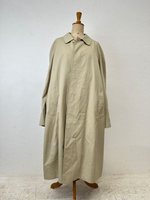 an image of a coat on a mannequin stand in front of a white wall