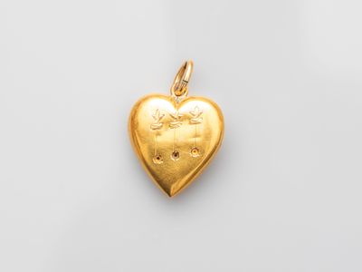 a gold heart shaped locke with a small diamond in the center