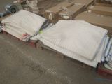 une pile de serviettes pliées posée sur une palette dans un entrepôt