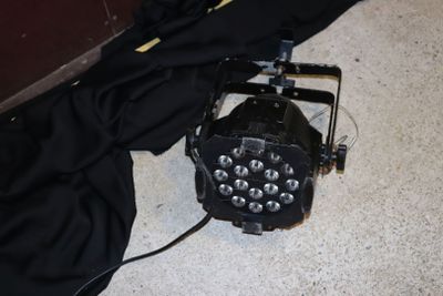 une lampe à lumière noire posée par terre à côté d'un sac noir