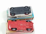 two toy cars sitting next to each other on a white surface