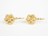 une paire de boucles d'oreilles en forme de fleurs dorées sur fond blanc