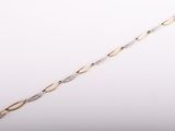 gros plan d'un bracelet en or et diamants sur fond blanc