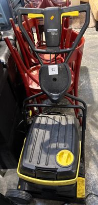 yellow and black lawn mower sitting on top of a pile of red chairs