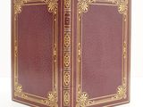a red book with gold trim and a gold border on the cover