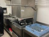 un homme debout dans une cuisine, à côté d'une cuisinière