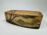 a ceramic bowl with a painting of trees on it
