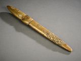 un gros plan d'un stylo en bois posé sur une surface grise