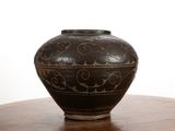 a black vase sitting on top of a wooden table