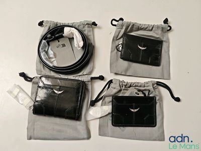 trois sacs contenant des objets noirs et blancs posés sur une table blanche