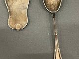 two spoons that are sitting next to each other on a table