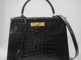 un sac à main en cuir de crocodile noir avec des finitions dorées