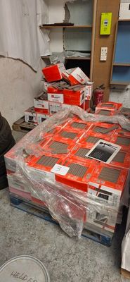 un homme qui se tient à côté d'un tas d'appareils électroniques