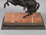 a statue of a man riding a horse on a marble base