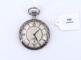 une montre de poche en argent posée sur une surface blanche, avec une étiquette de prix