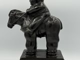statue of a man on a horse with a hat and a top hat