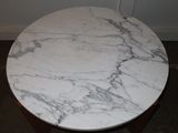 a marble table with a wooden base in a room