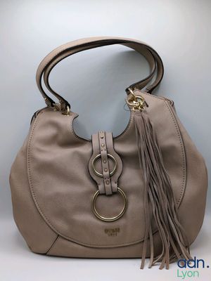 the handbag is made of leather and has a tassel on the handle
