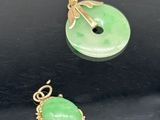trois bijoux en jade vert et en or sur un fond noir