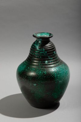 a green vase that is sitting on a table