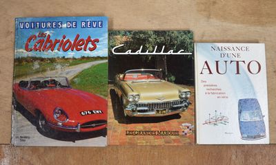 deux livres posés sur une table, avec une voiture rouge et une voiture jaune