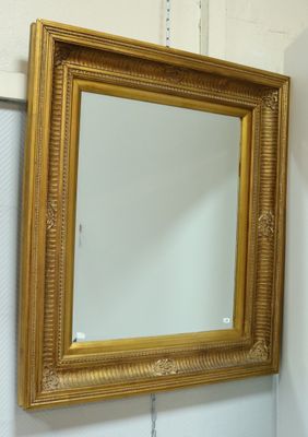 un miroir sur le mur au-dessus d'un lavabo dans une salle de bains