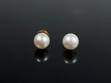 une paire de boucles d'oreilles en perles sur une surface noire