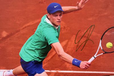photo dédicacée d'un joueur de tennis en train de frapper une balle de tennis avec une raquette