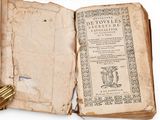 an open book with a gold key on top of it