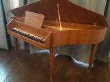 a piano that is sitting on the floor in front of a window