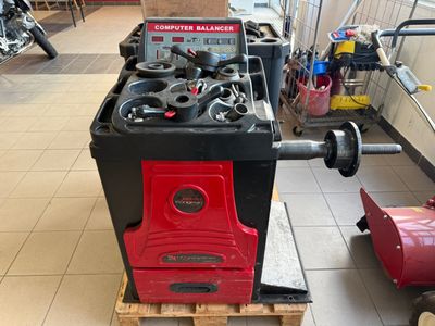 a red and black stove sitting on a pallet in a garage