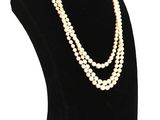 un collier de perles blanches sur un mannequin noir