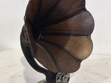 un petit gramophone en bois posé sur un support, lui-même posé sur une table